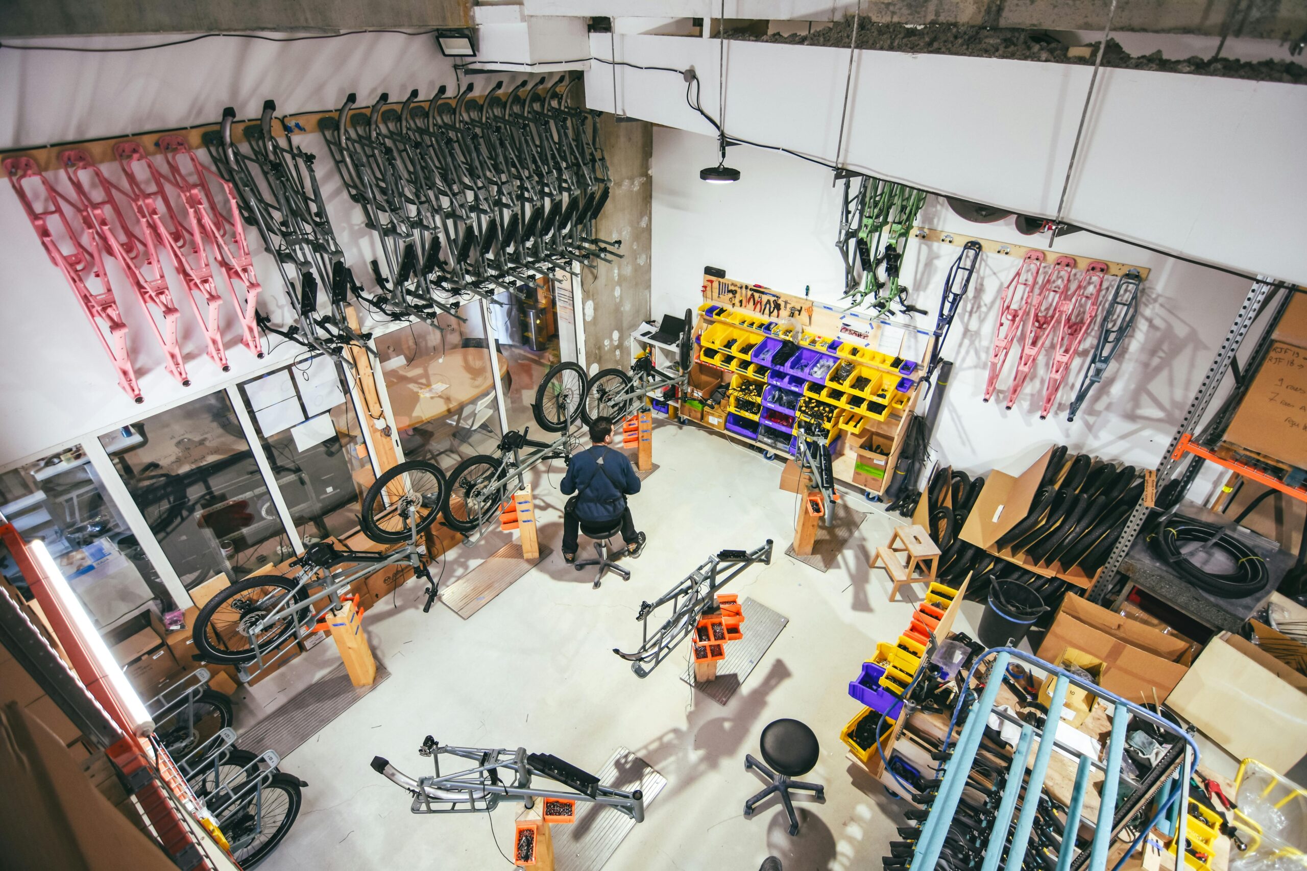 A comprehensive look into a bicycle workshop with frames and parts organized for assembly.